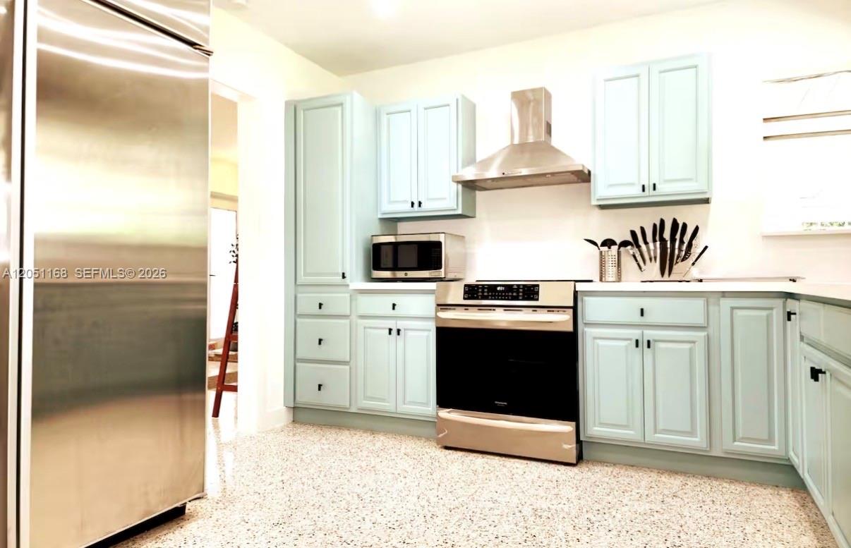 A kitchen features light blue cabinets, stainless steel appliances, and speckled flooring — 29450 SW 180th Ave, Homestead FL 33030, HOMESTEAD, FL