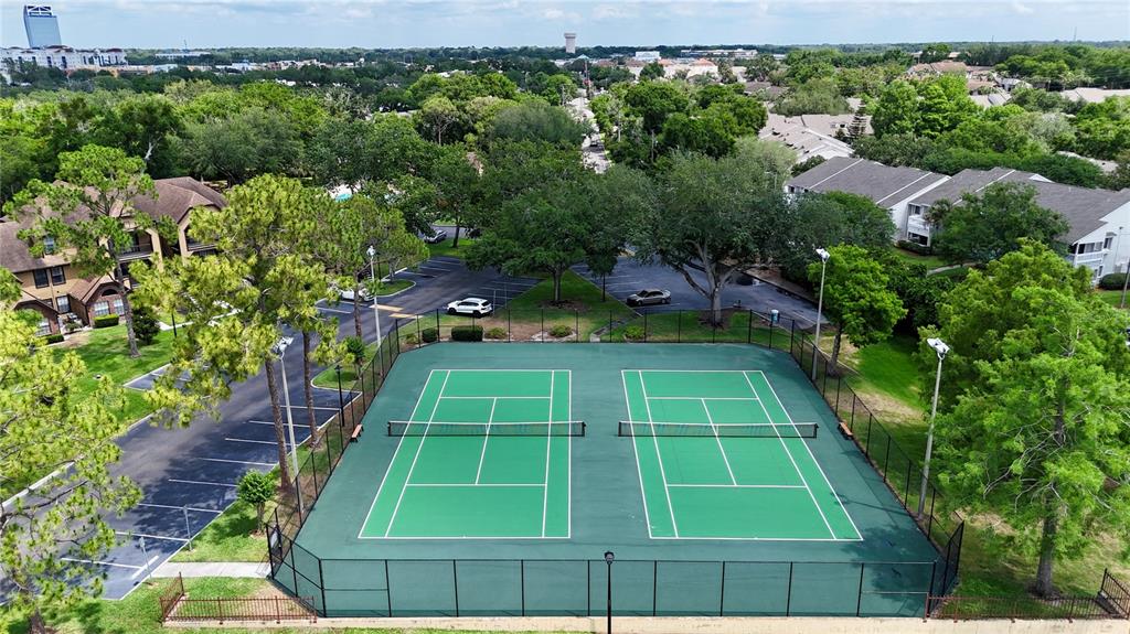 An aerial view shows two green tennis courts enclosed by a black chain-link fence — 315 LAKEPOINTE DRIVE UNIT 101, ALTAMONTE SPRINGS, FL