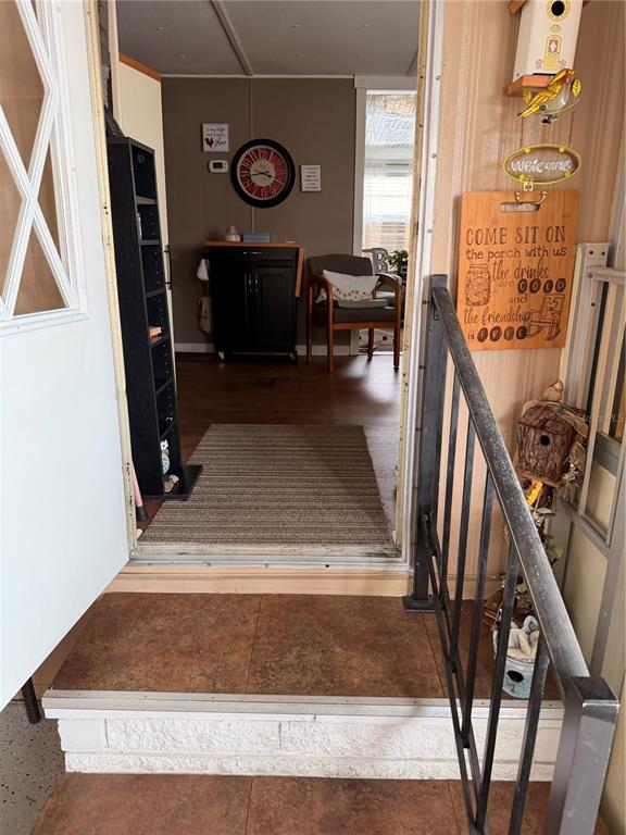 A view through an open doorway into a living area with a rug and chair — 38533 LANSING AVENUE, ZEPHYRHILLS, FL