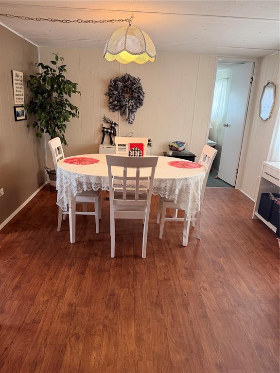 A dining area features a white table with four chairs, wood-look flooring, and a pendant light — 38533 LANSING AVENUE, ZEPHYRHILLS, FL