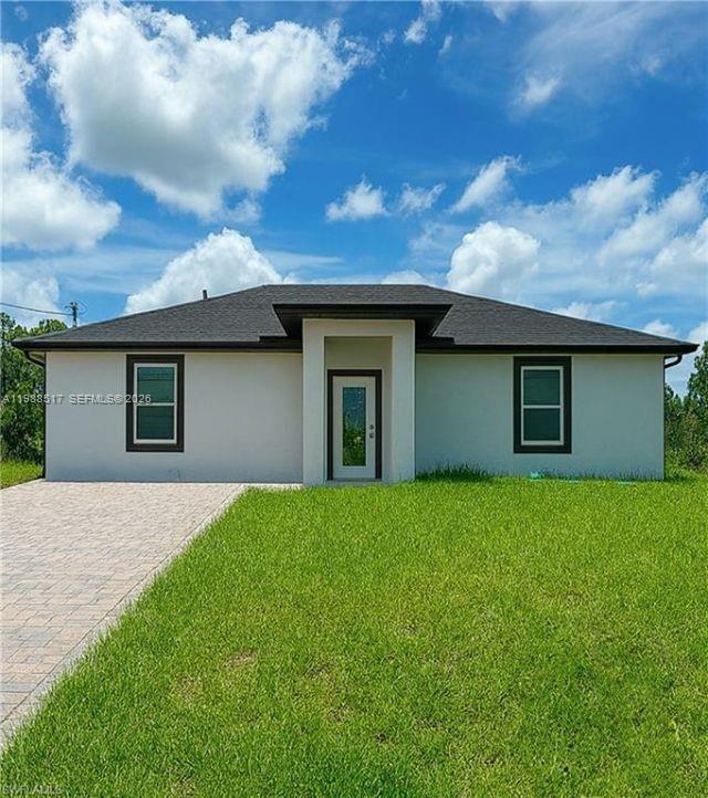 A single-story house with a white stucco exterior, dark roof, and a paved driveway — 816 Palomino, Lehigh Acres FL 33974, LEHIGH ACRES, FL