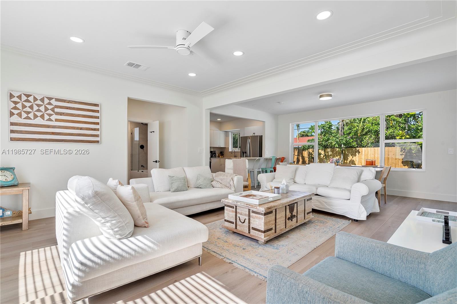 A white, single-story house features a concrete driveway with grass strips and a front lawn — 10801 Peachtree Dr, Miami FL 33161, MIAMI, FL