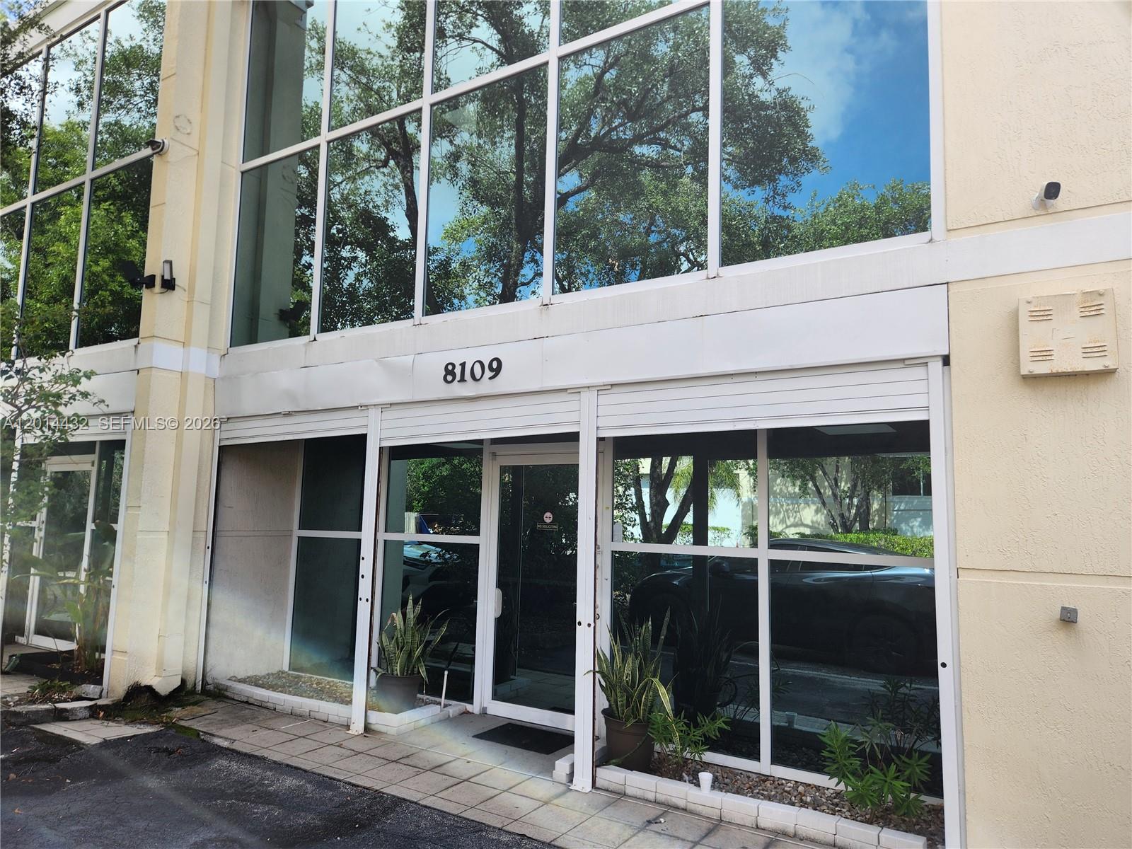 The exterior of a commercial building features large glass windows and a central glass door — 8109 NW 29th St # 8109, Doral FL 33122, DORAL, FL