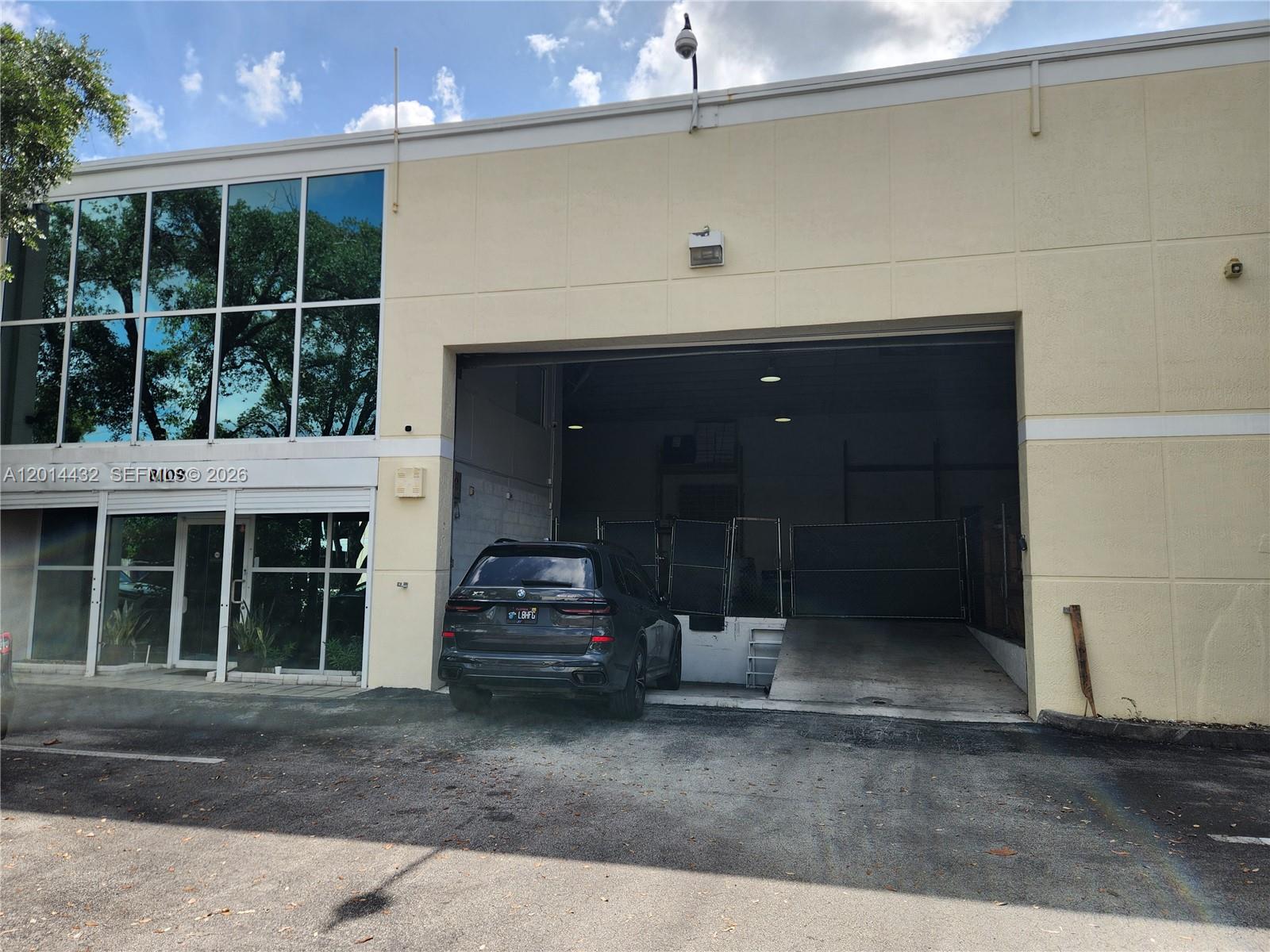 A dark SUV is parked in front of a commercial building with a loading bay — 8109 NW 29th St # 8109, Doral FL 33122, DORAL, FL