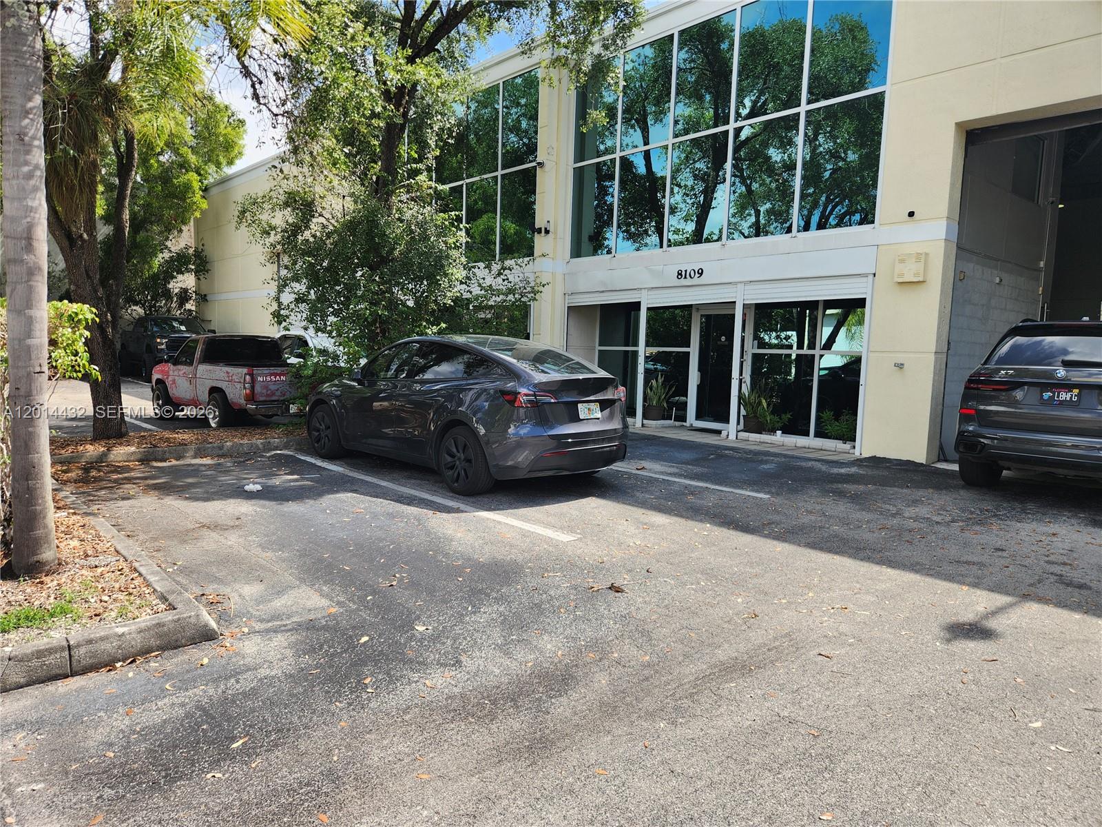 A gray Tesla and a black SUV are parked in front of a commercial building — 8109 NW 29th St # 8109, Doral FL 33122, DORAL, FL