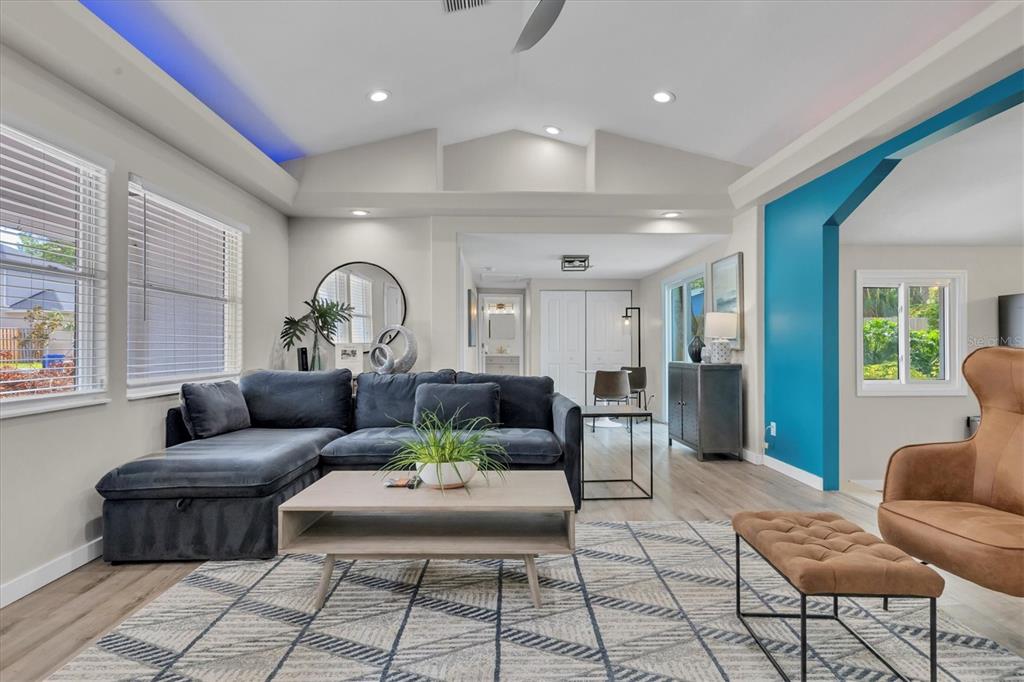 A living room features a dark blue sectional sofa, a coffee table, and blue accent walls — 4110 IOLA DRIVE, SARASOTA, FL