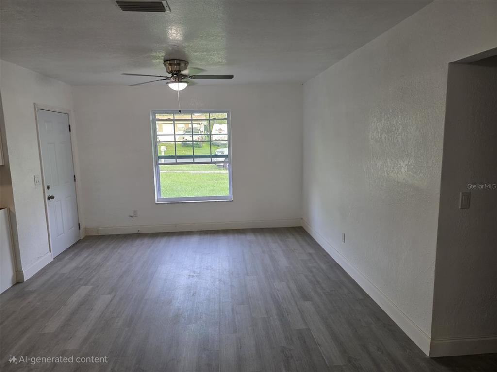 An empty room features white walls, a ceiling fan, and light-colored wood-look flooring — 1869 W FREEMAN PLACE, CITRUS SPRINGS, FL