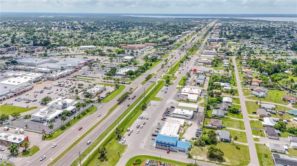 An aerial view shows a multi-lane highway running through a suburban area with commercial buildings — 3231 TAMIAMI TRAIL UNIT A-G, PORT CHARLOTTE, FL
