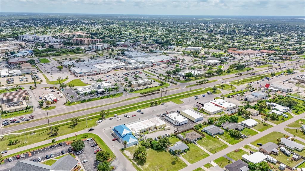 An aerial view shows a commercial area with parking lots, retail buildings, and a highway — 3231 TAMIAMI TRAIL UNIT A-G, PORT CHARLOTTE, FL