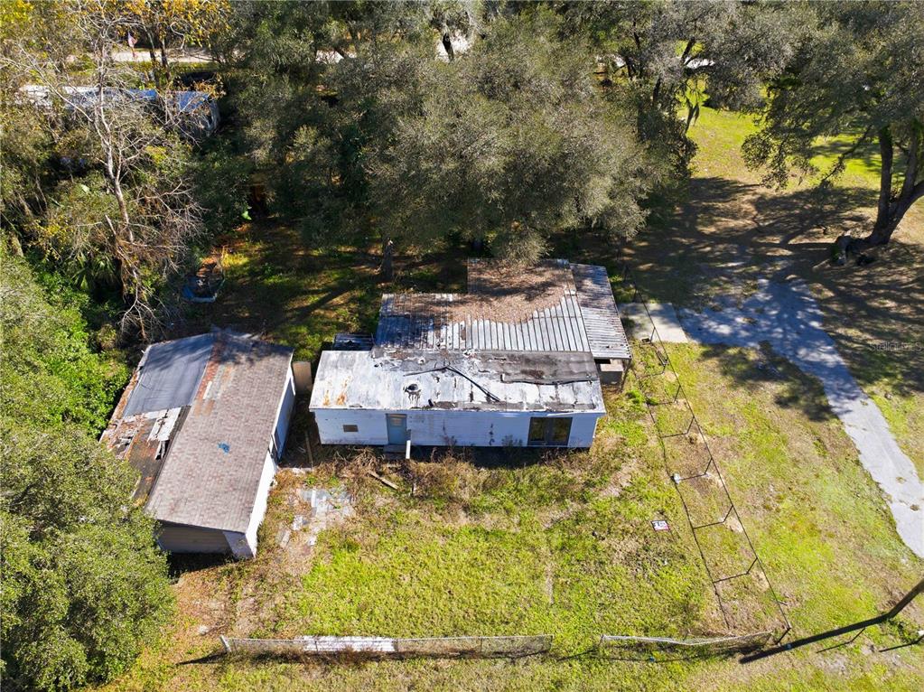 An aerial view shows a weathered house and detached garage on a wooded, grassy lot — 4265 S ILLIANA TERRACE, INVERNESS, FL