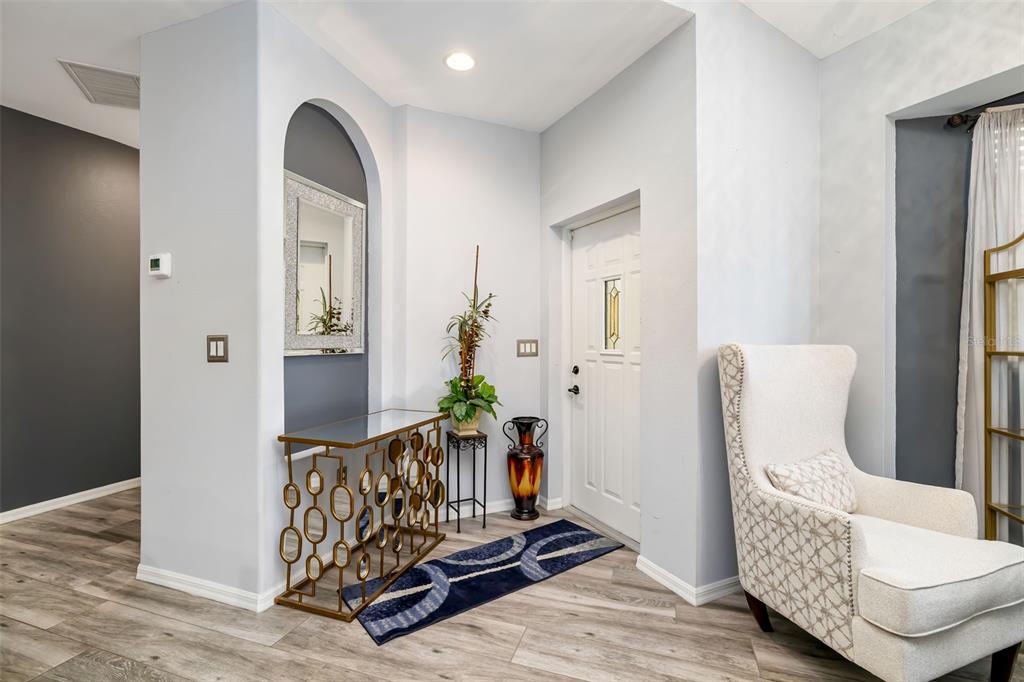 An entryway features light gray walls, wood-look flooring, an arched wall niche, and a white door — 411 28TH STREET W, PALMETTO, FL