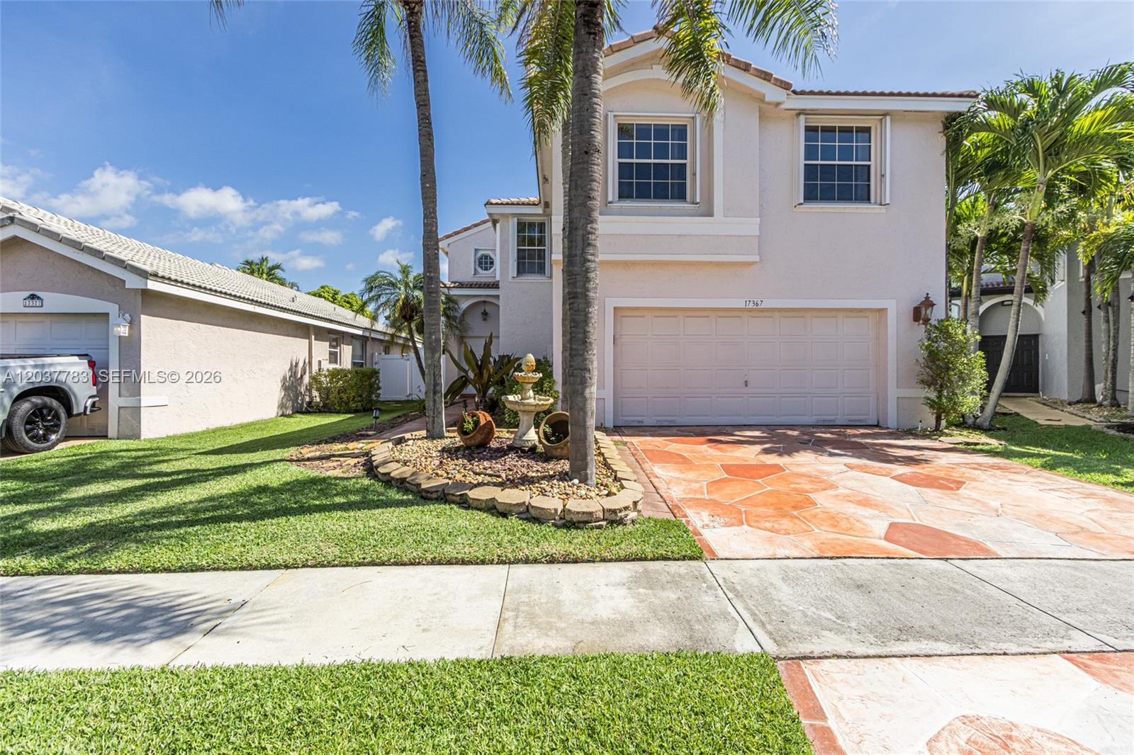 A two-story house features a paved driveway, a small fountain, and palm trees — 17367 SW 20th Ct, Miramar FL 33029, MIRAMAR, FL
