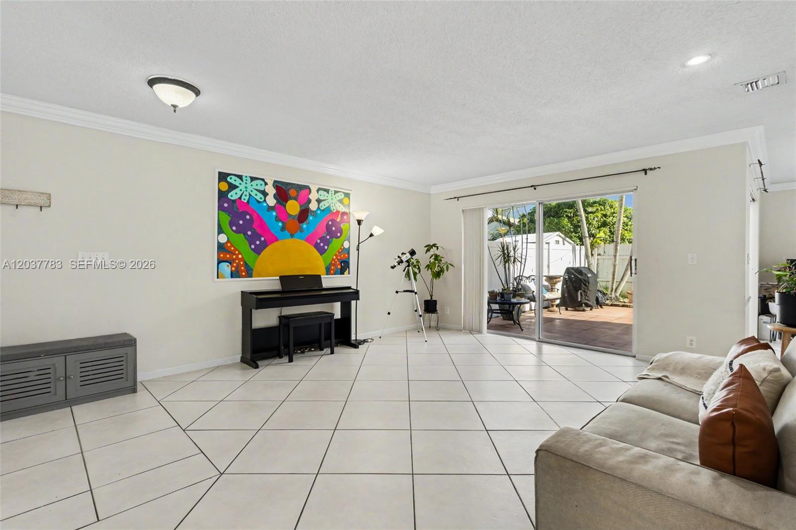 A living room features white tiled floors, a piano, a telescope, and sliding glass doors — 17367 SW 20th Ct, Miramar FL 33029, MIRAMAR, FL