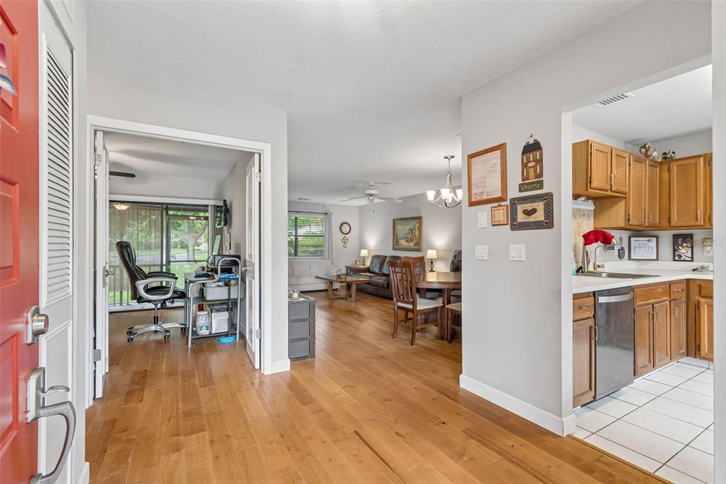 An entryway leads to a living area with wood floors, a kitchen, and a home office — 2903 FIG COURT, PALM HARBOR, FL