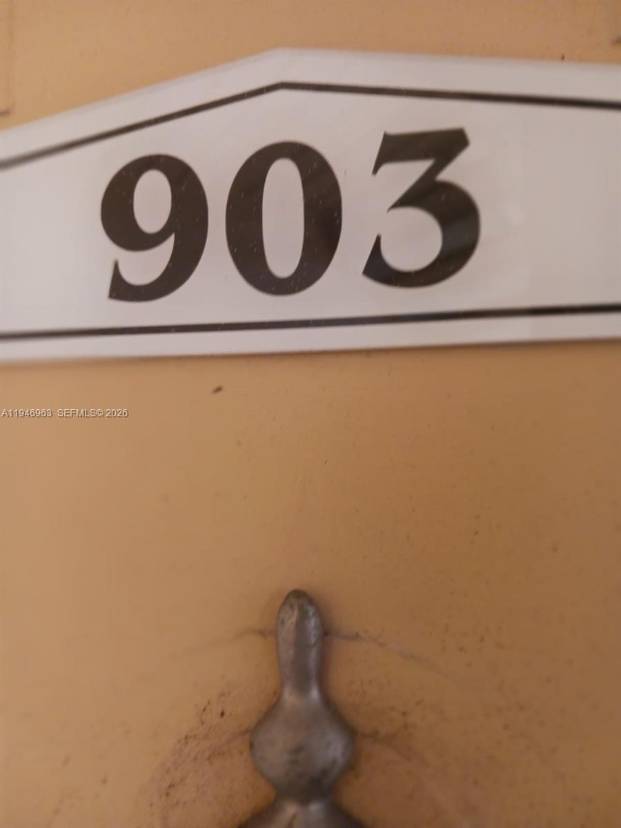A close-up view of a white door sign displaying the number 903 — 1239 SW 46th Ave # 903, Pompano Beach FL 33069, POMPANO BEACH, FL