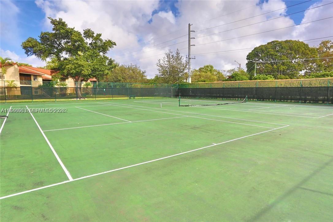A green outdoor tennis court is enclosed by a tall chain-link fence — 1239 SW 46th Ave # 903, Pompano Beach FL 33069, POMPANO BEACH, FL