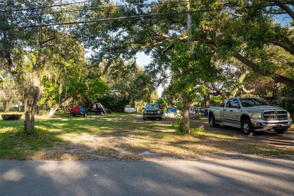 A large, grassy, tree-shaded lot with a parked pickup truck and various trailers — 6027 98TH WAY N, ST PETERSBURG, FL