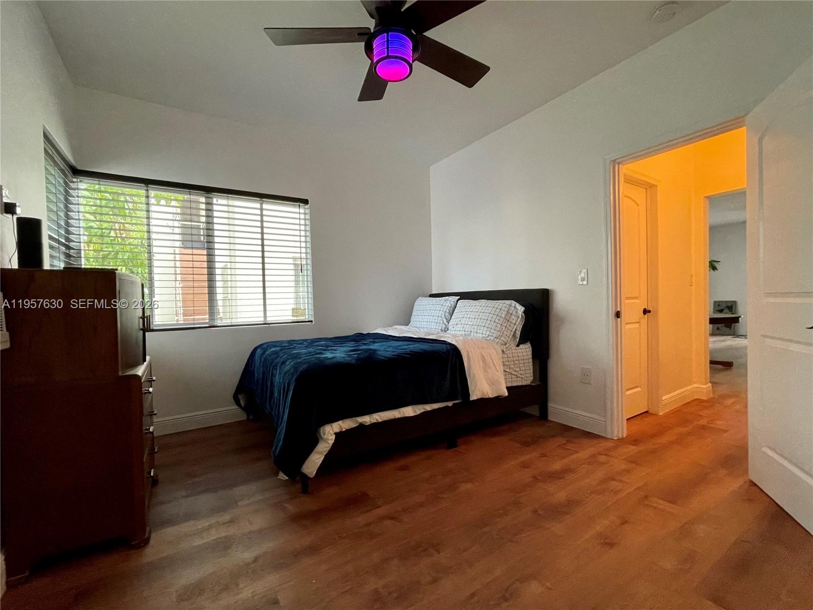 A bedroom features a bed, a dresser, a ceiling fan, and wood-look flooring — 2463 Pine Tree Dr # 4, Miami Beach FL 33140, MIAMI BEACH, FL