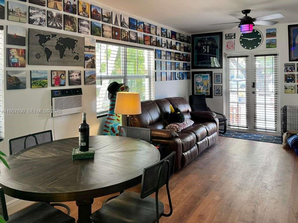 A living and dining area features a gallery wall, brown leather sofa, and round table — 2463 Pine Tree Dr # 4, Miami Beach FL 33140, MIAMI BEACH, FL