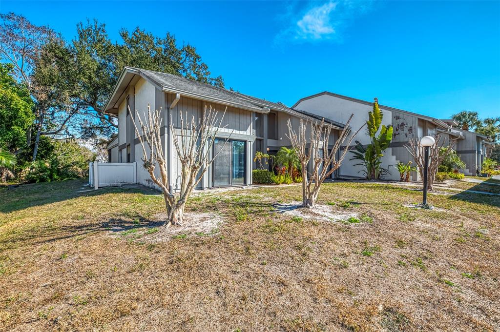 A two-story tan apartment building with sliding glass doors and bare trees in the yard — 984 N BENEVA ROAD UNIT T7, SARASOTA, FL