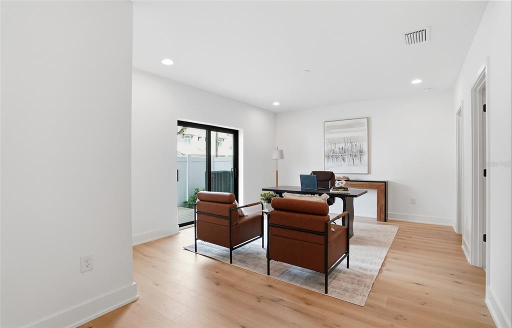 A home office features light wood flooring, two brown leather chairs, and a sliding glass door — 3002 W PLATT UNIT 3, TAMPA, FL