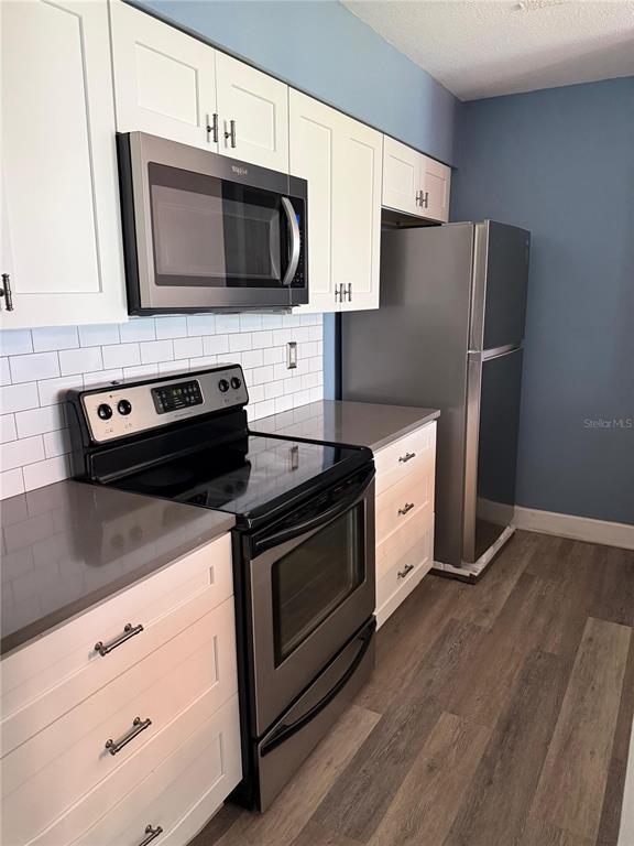 A kitchen features white cabinets, stainless steel appliances, gray countertops, and a white subway tile backsplash — 2235 FLUORSHIRE DRIVE, BRANDON, FL