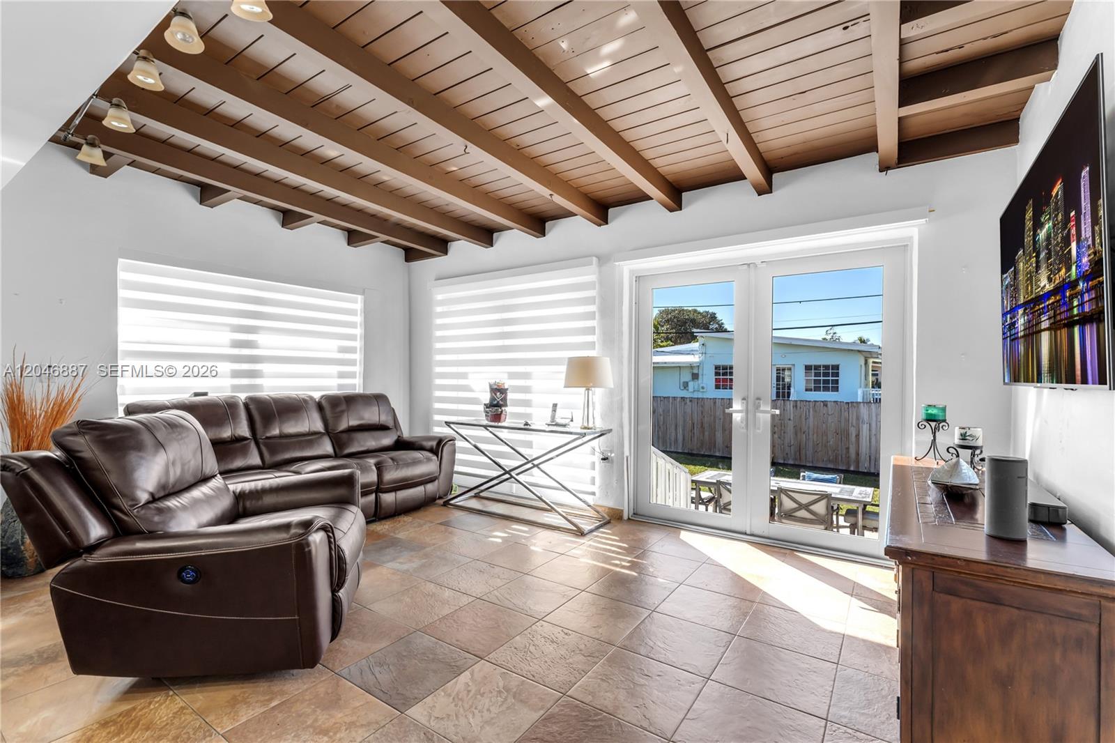 A living room features tile floors, a wood-beamed ceiling, and glass doors leading outside — MIAMI, FL