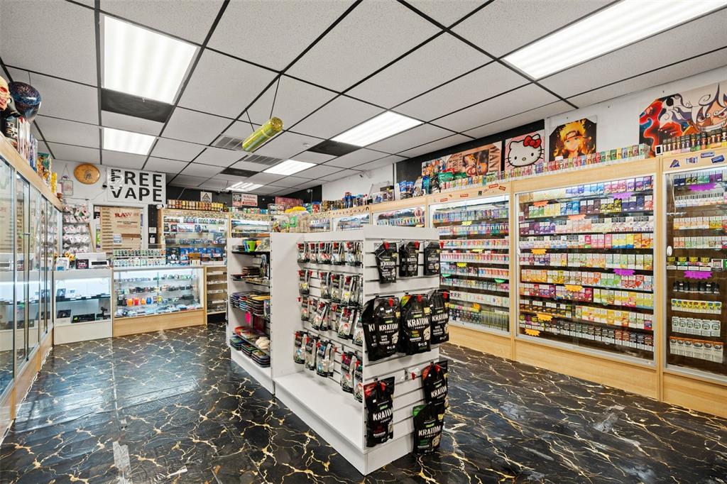 An interior view of a retail smoke shop featuring glass display cases and product shelving — 49TH STREET, PINELLAS PARK, FL