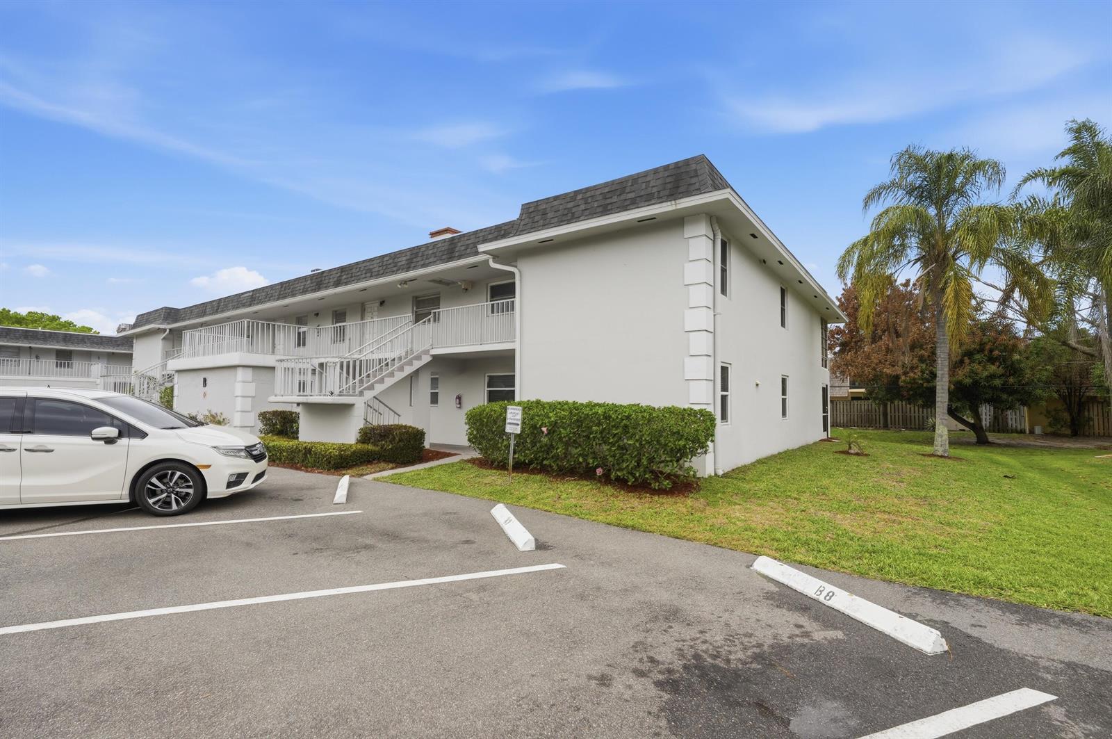 A two-story apartment building with white stucco walls, a dark roof, and an exterior staircase — 1166 6th Avenue # B8, Vero Beach FL 32960, VERO BEACH, FL