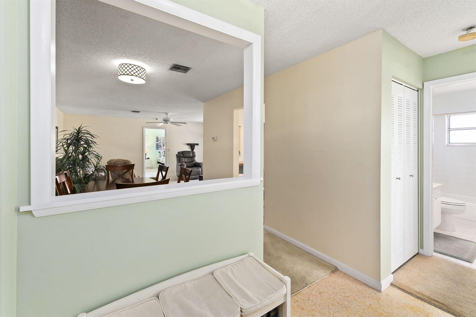 A view from a hallway looking through a pass-through window into a dining area — 533 S Lakes End Drive # D2, Fort Pierce FL 34982, FORT PIERCE, FL