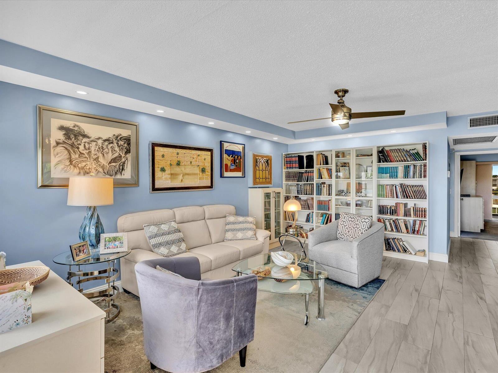A living room features light blue walls, a beige sofa, armchairs, and built-in bookshelves — 4038 Swansea B, Deerfield Beach FL 33442, DEERFIELD BEACH, FL