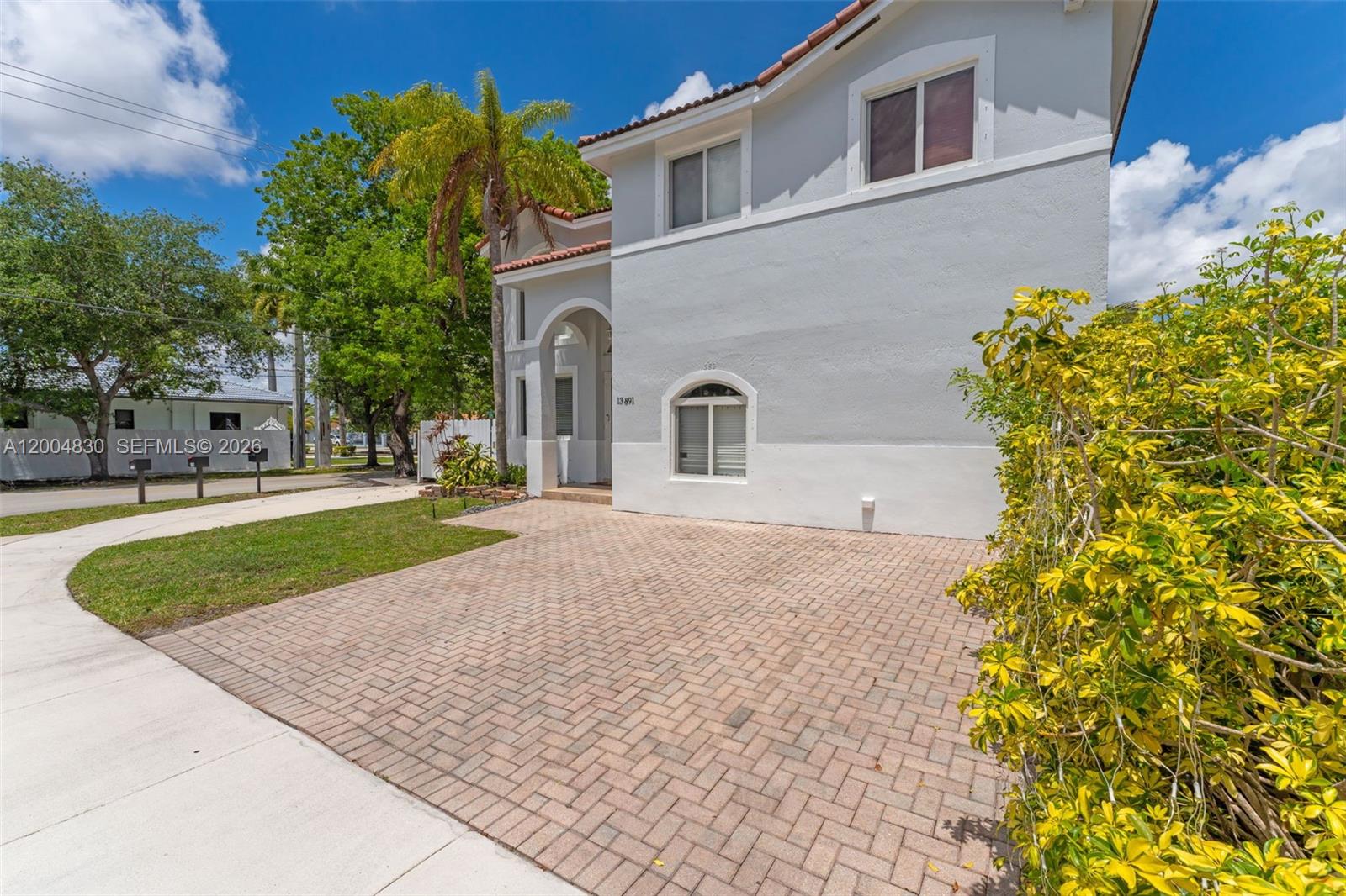 A two-story house with a paved driveway, light-colored stucco walls, and a tiled roof — 13891 SW 39th Ter, Miami FL 33175, MIAMI, FL