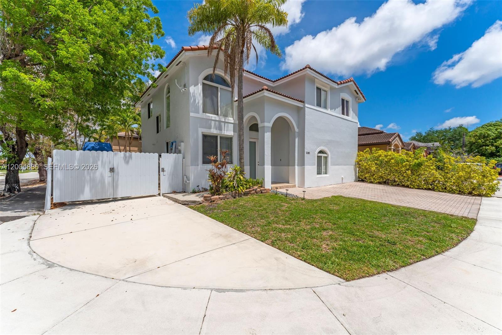 A two-story stucco house features a palm tree, arched windows, and a paved driveway — 13891 SW 39th Ter, Miami FL 33175, MIAMI, FL