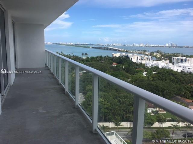 A balcony with a glass railing overlooks a bay, a bridge, and coastal buildings — 4250 Biscayne Blvd # 1517, Miami FL 33137, MIAMI, FL