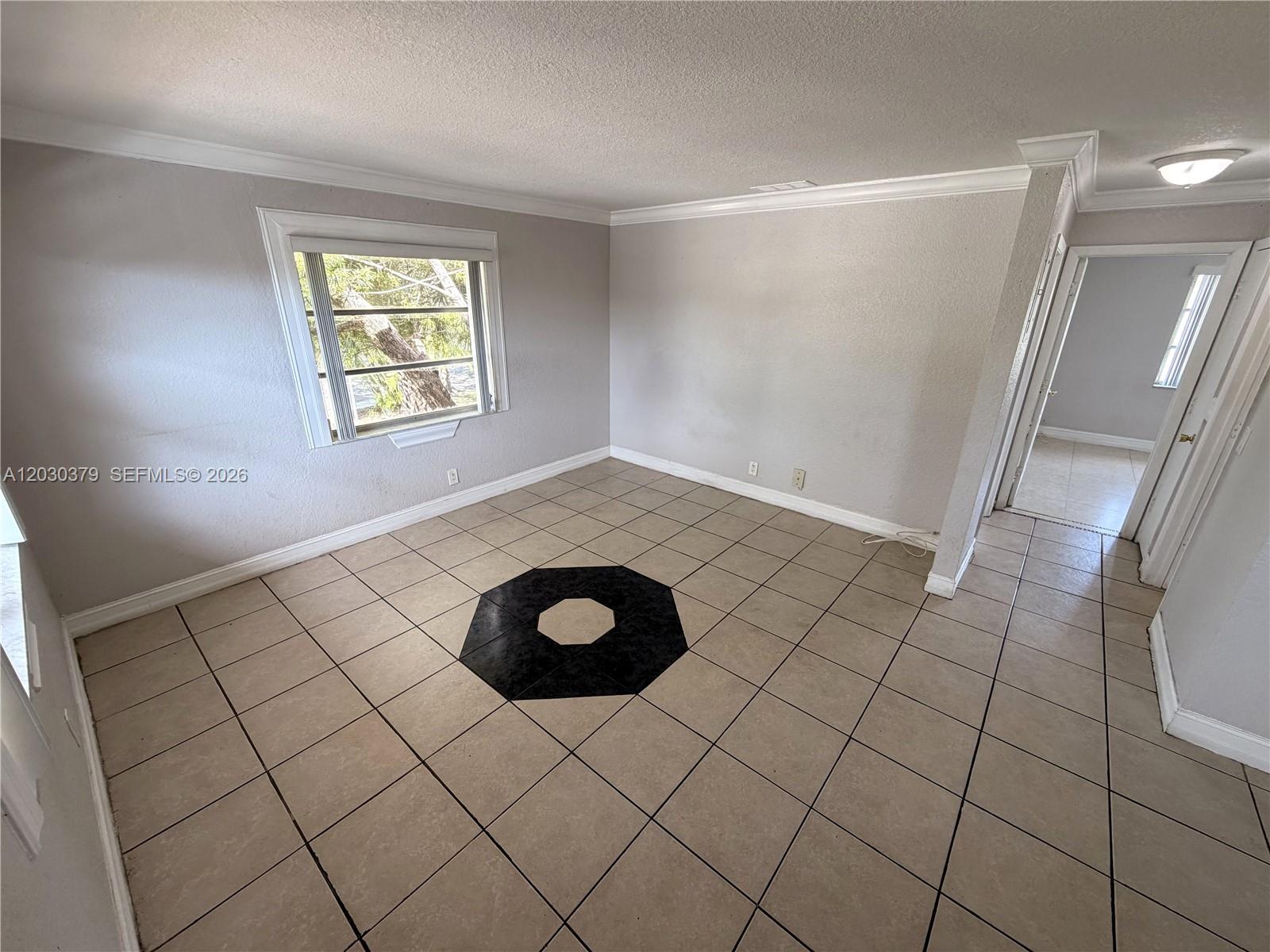 An empty room features light-colored tile flooring with a central black octagonal decorative inlay — 412 Lakeside Dr # 223, Margate FL 33063, MARGATE, FL
