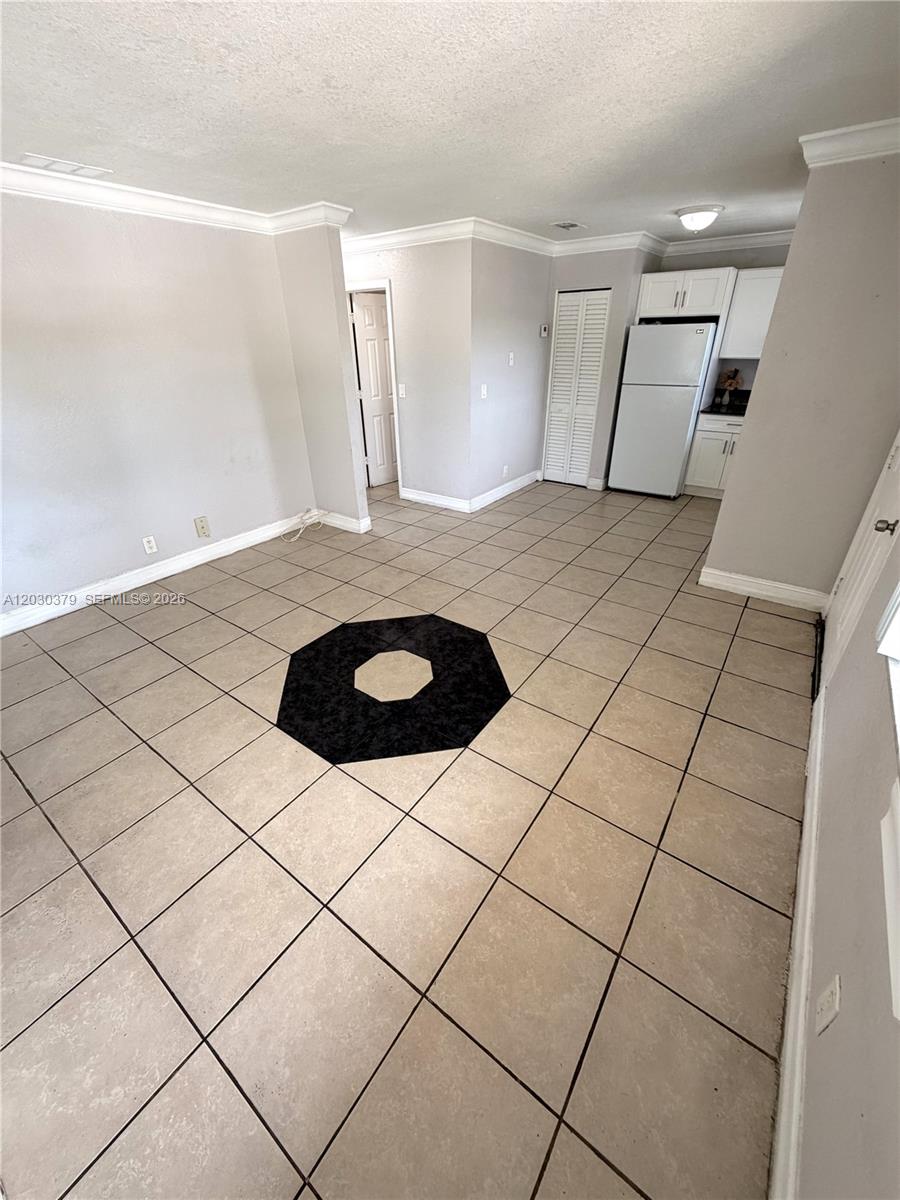 An open-plan living area features beige tile flooring with a central black octagonal accent tile — 412 Lakeside Dr # 223, Margate FL 33063, MARGATE, FL