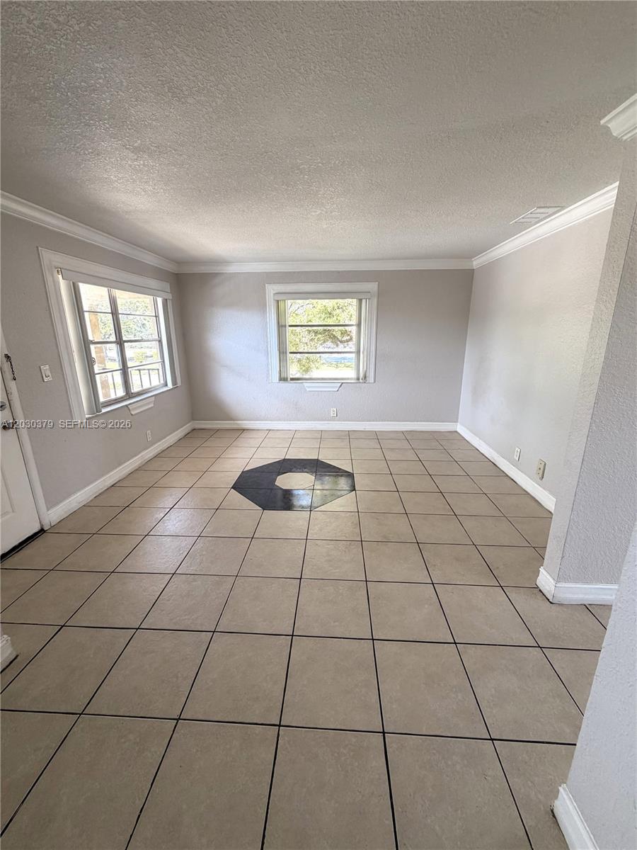An empty room features light-colored tile flooring with a dark octagonal accent and two windows — 412 Lakeside Dr # 223, Margate FL 33063, MARGATE, FL