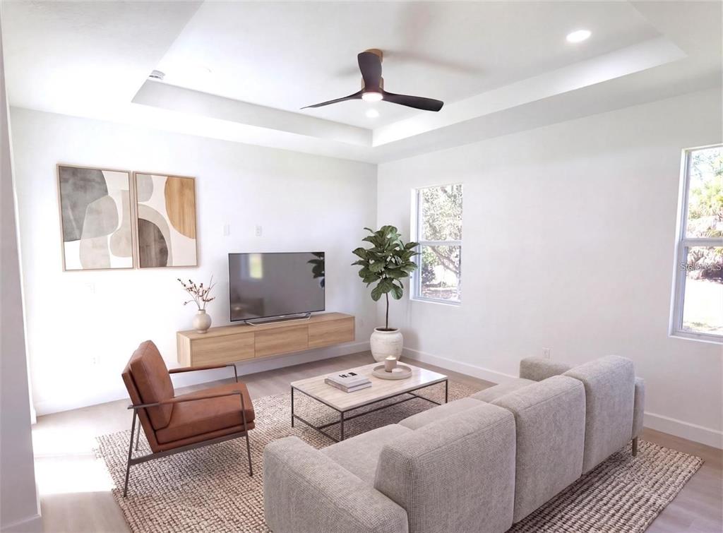A modern living room features a tray ceiling, a floating media console, and neutral furniture — 2074 RIBBON TERRACE, NORTH PORT, FL