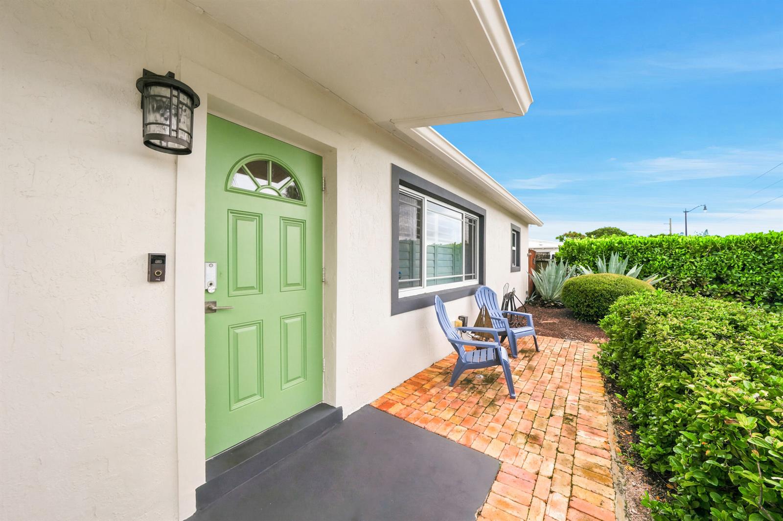 A light green front door opens onto a brick patio with two blue chairs — 3140 NE 12th Avenue, Pompano Beach FL 33064, POMPANO BEACH, FL