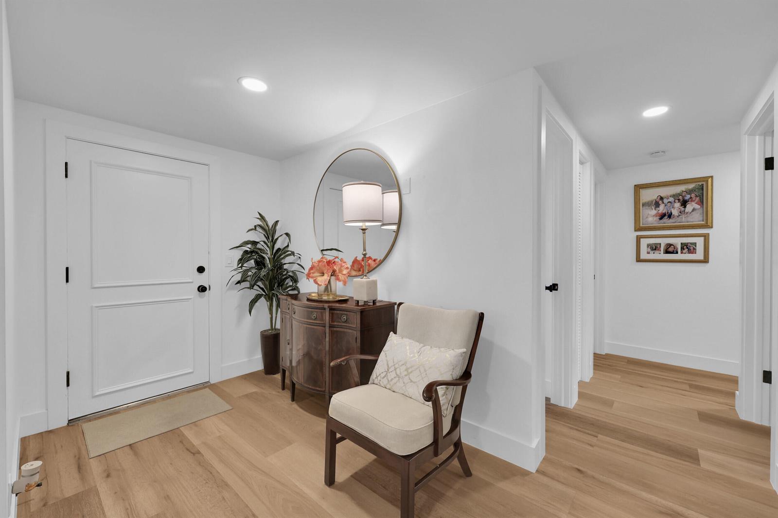 A bright entryway features a white door, a wooden console table, a mirror, and a chair — 10 SE Turtle Creek Drive Unit B, Tequesta FL 33469, TEQUESTA, FL