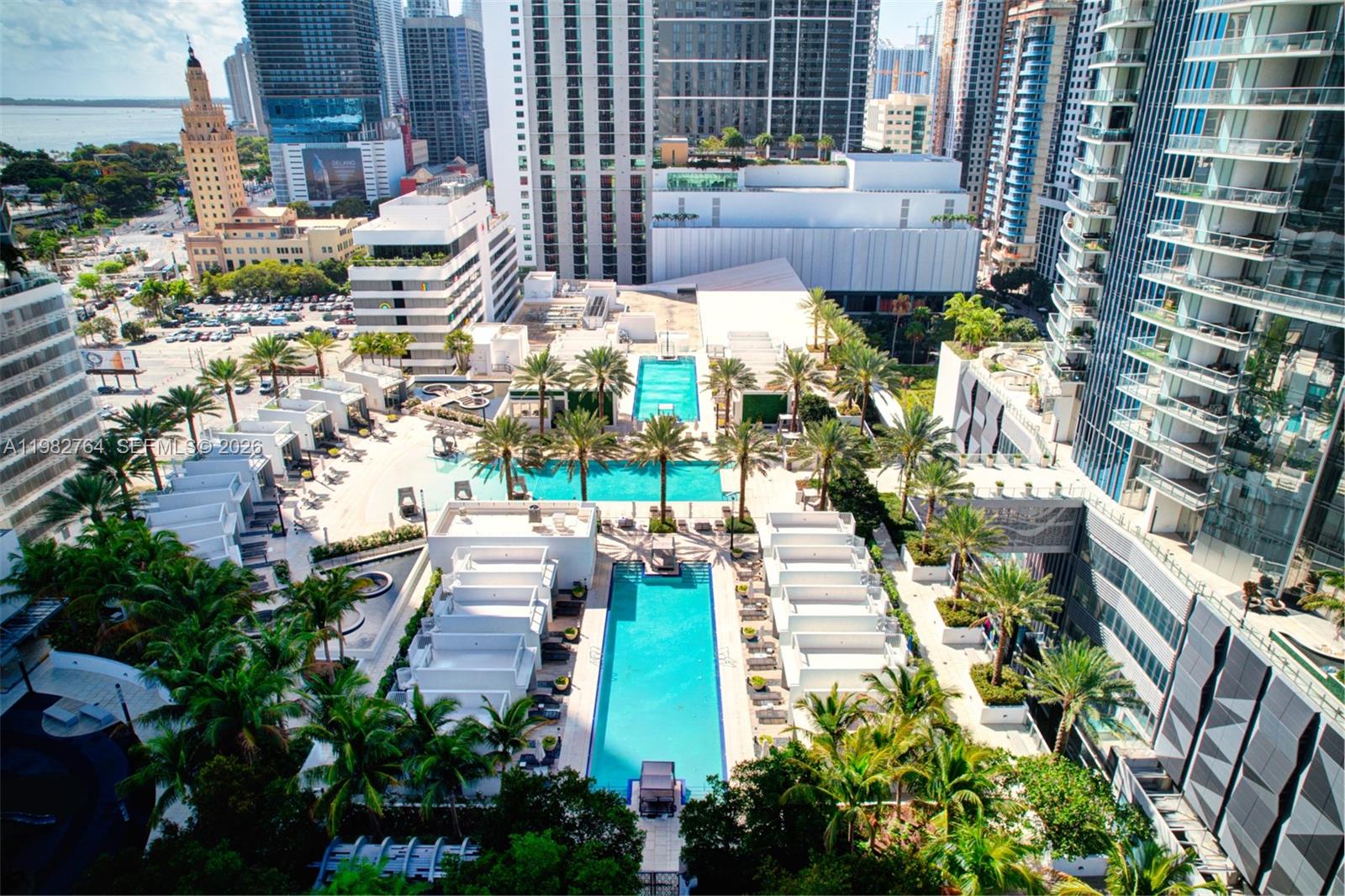 An aerial view shows a hotel pool deck surrounded by palm trees and high-rise buildings — 851 NE 1st Ave # 4801, Miami FL 33132, MIAMI, FL