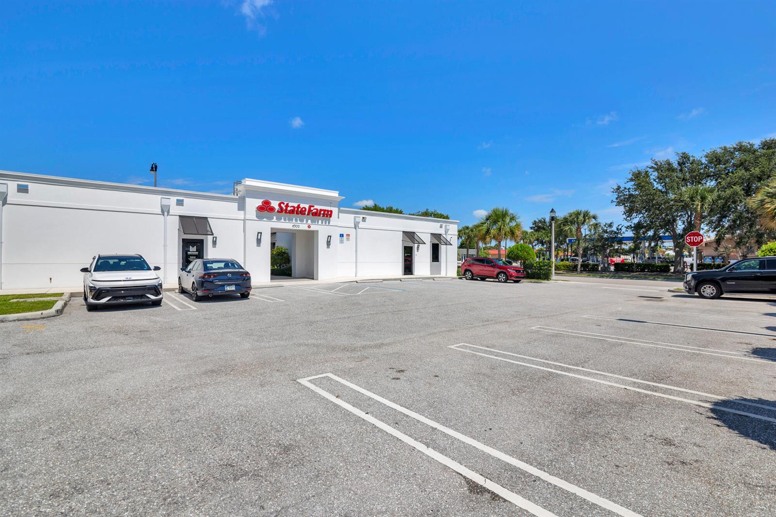A white commercial building with a State Farm sign sits behind a paved parking lot — 6500 S Dixie Highway # C, West Palm Beach FL 33405, WEST PALM BEACH, FL