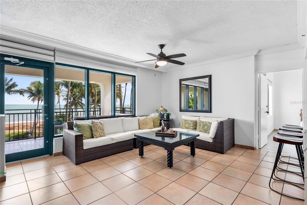A living room with tile floors, a sectional sofa, and a balcony overlooking the ocean — 6100 RIO MAR UNIT 829899, RIO GRANDE, PR