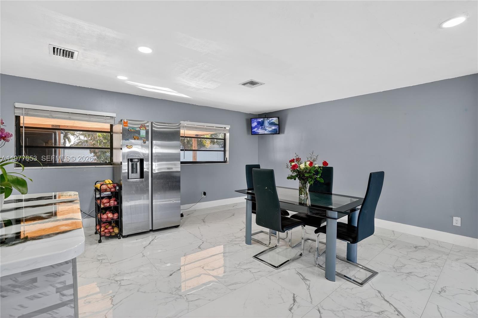 A dining area features gray walls, white marble-patterned tile floors, and a glass-top table — 1318 13th St, West Palm Beach FL 33401, WEST PALM BEACH, FL