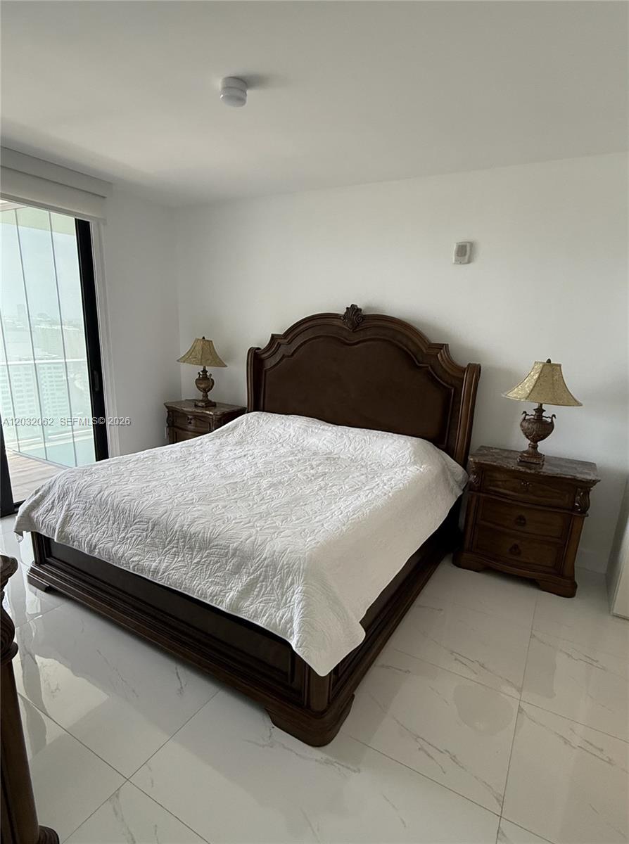 A bedroom features a dark wood bed frame, two matching nightstands, and white tile flooring — 1010 Brickell Ave # 2704, Miami FL 33131, MIAMI, FL