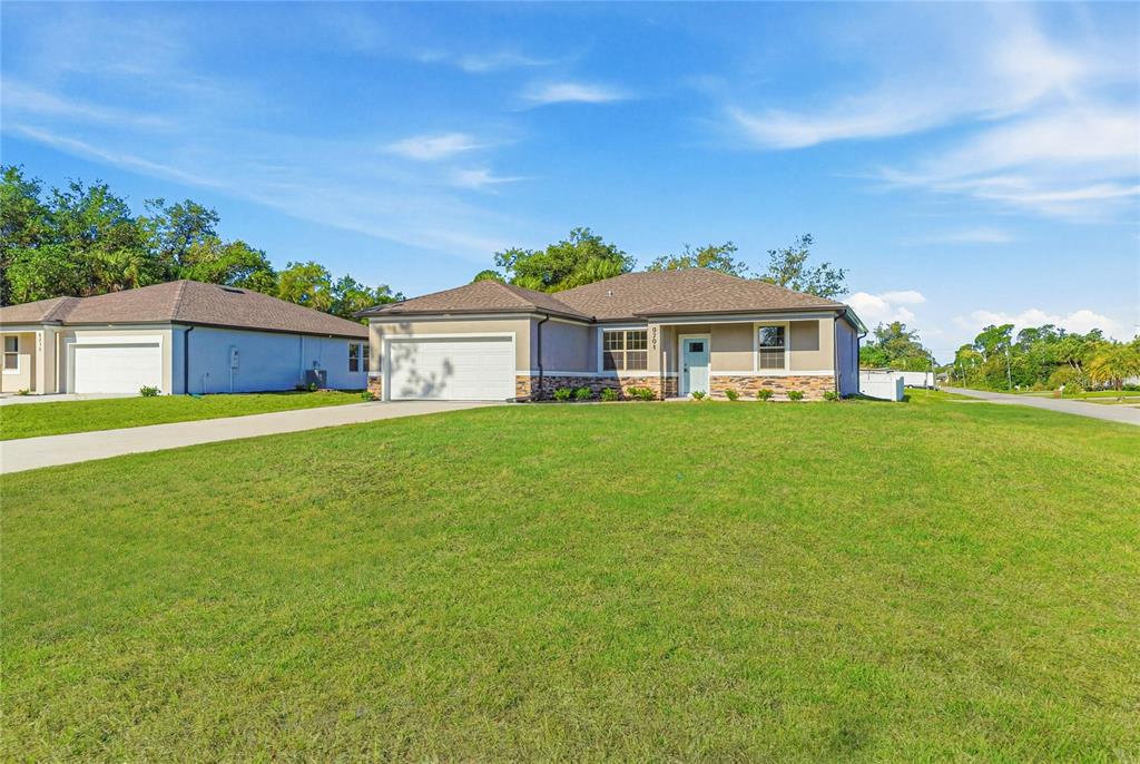 A single-story suburban house with a two-car garage and a large front lawn — 5101 S SAN MATEO DRIVE, NORTH PORT, FL