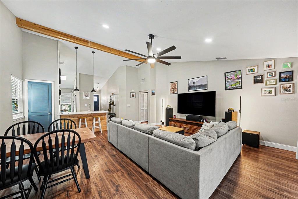 A living room with a sectional sofa, wood flooring, and a vaulted ceiling with beams — 6209 INTERBAY BOULEVARD, TAMPA, FL