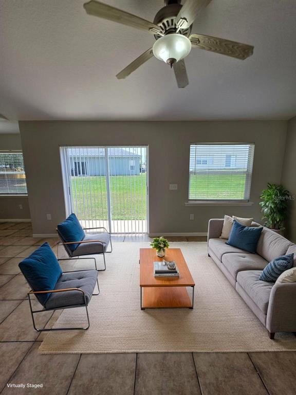 A living room features a sofa, two armchairs, a coffee table, and sliding glass doors — 106 HERRING LANE, POINCIANA, FL