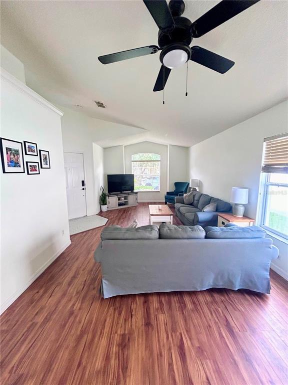 A kitchen with a dark blue island and white countertops opens into a living area — 1061 PORTMOOR WAY, WINTER GARDEN, FL