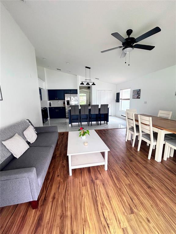 A bedroom features a white bed, wood-look flooring, a ceiling fan, and sliding glass doors — 1061 PORTMOOR WAY, WINTER GARDEN, FL